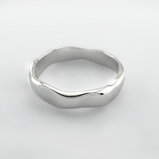 Silver ring with a wave design on a light grey background