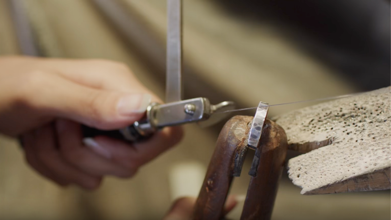Close up of jewellery sawing through a silver ring
