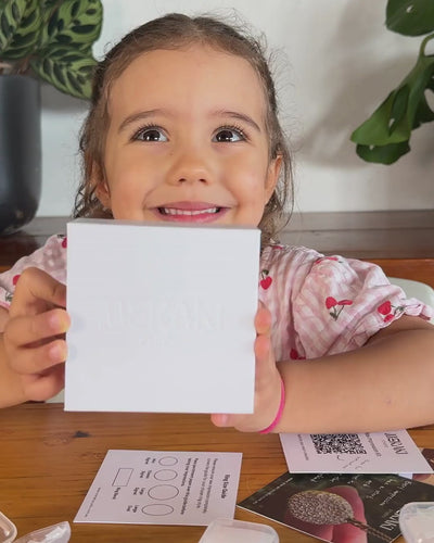 Child holding up white wax impression kit gift box