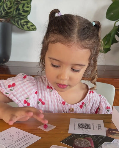 Child pressing finger into red ball of wax leaving a fingerprint impression