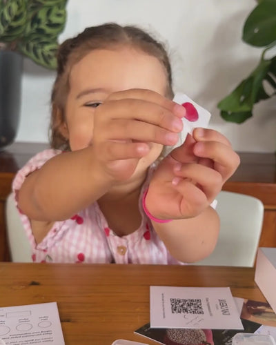 Child holding up red wax fingerprint impression